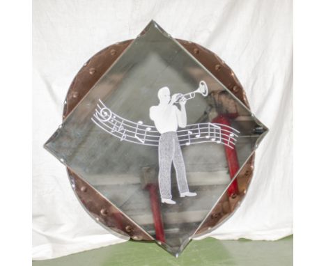 An Art Deco pink and clear wall mirror with trumpet player, 76cm square