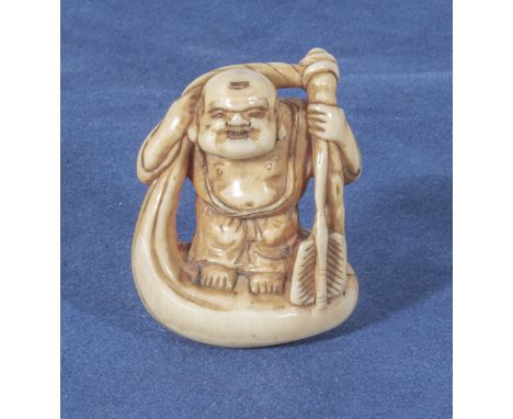 An antique netsuke of a man on a raft, 1.25"