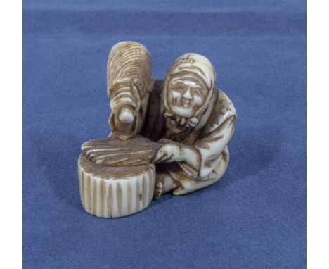 An antique Japanese netsuke depicting a woman threshing rice, 1.25"