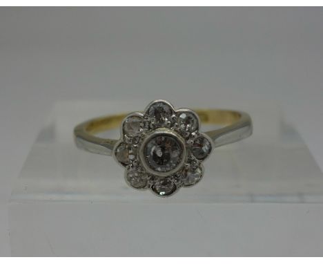 An Edwardian 18ct gold and platinum set diamond daisy cluster ring, weight 2.6g, size M