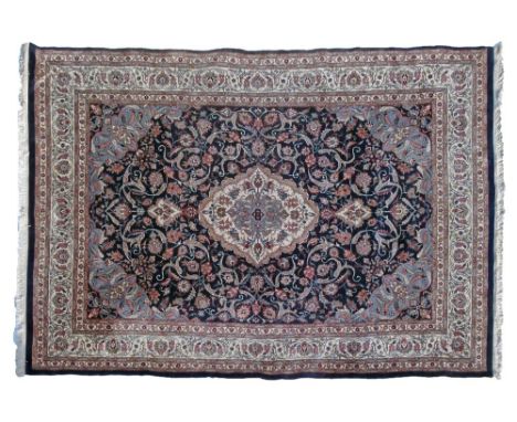 Good quality modern Middle Eastern carpet decorated with a central medallion on a stylised floral patterned dark blue ground 