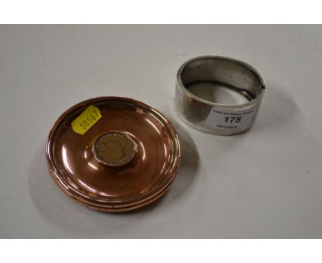 Two copper dishes inset with coins together with a silver bangle 
