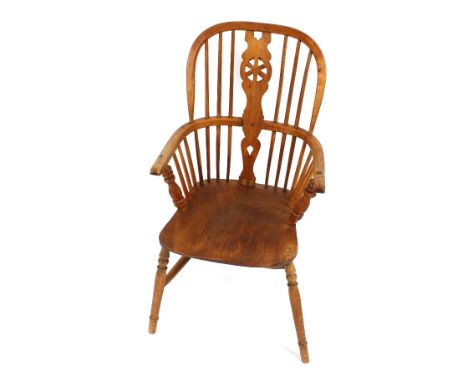 A 19th Century elm stick and wheel back Windsor chair, raised on turned supports united by a H stretcher 