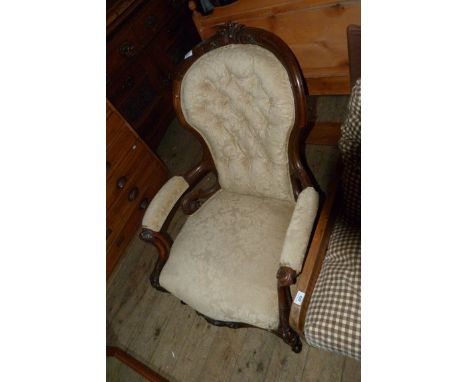 A Victorian walnut framed button back armchair upholstered in floral fabric 