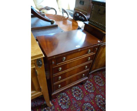 A good quality reproduction mahogany small bachelors style chest with fold over top over four drawers raised on bracket feet 