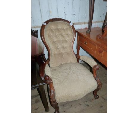 A Victorian walnut framed button back armchair upholstered in beige floral fabric 