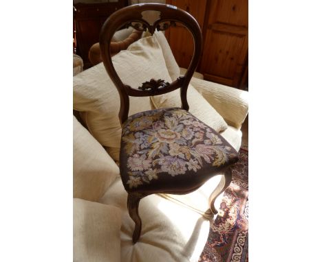 A set of four Victorian mahogany balloon back and cabriole legged dining chairs with tapestry upholstered seats