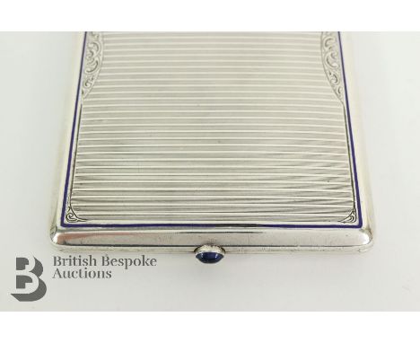 A Continental Art Deco 900 silver and blue enamel card case, having a gilded interior, with cabochon sapphire button catch, a