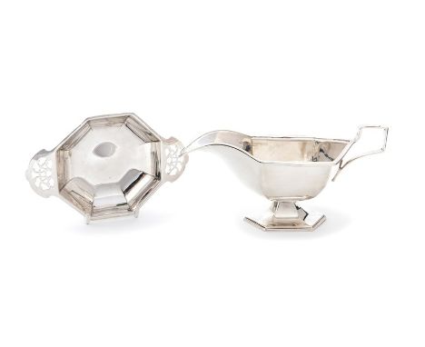 An Art Deco silver plain oval sauce boat with geometric facet sides with similar handle and raised foot, the border with sunb