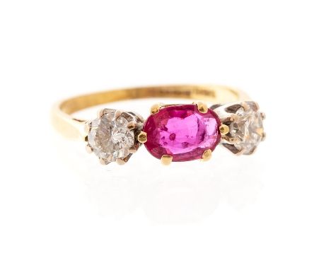 A ruby and diamond three stone 18ct gold ring, the centrally claw set oval cut ruby weighing approx 0.80ct,  set either side 