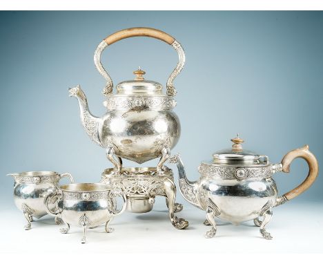 An early 20th Century Irish Celtic Revival matched four piece tea service, including tea kettle on stand with burner, teapot,
