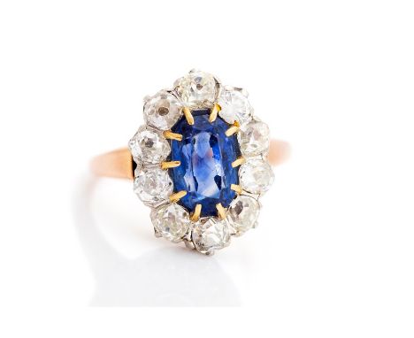 A sapphire and diamond oval cluster ring, the central rectangular cushion cut accompanied by a G.C.S sapphire report stating 