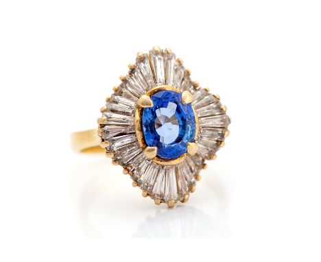 A sapphire and diamond fancy quatrafoil shaped cluster ring, the central oval cut blue sapphire accompanied by a G.C.S sapphi