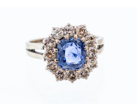 A sapphire and diamond cushion shaped cluster 18ct white gold ring, the central cushion cut sapphire weighing approx 2.75cts,