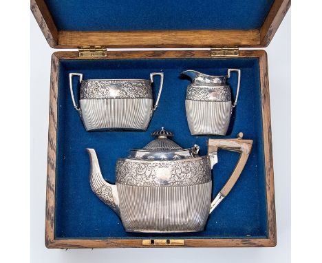 A Victorian silver tea set, comprising teapot, sugar bowl and cream jug, foliate floral and scroll decoration to upper band w
