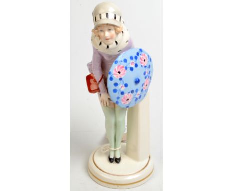 A 1920's German ceramic figure of a flapper caught out by the elements. Moulded mark Germany 4534. Height 23.5cm. 