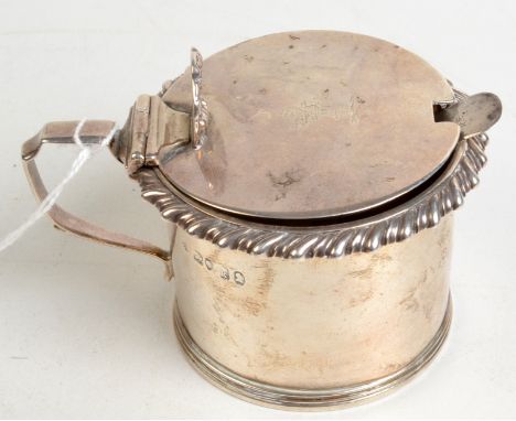 A George IV cylindrical silver mustard pot with gadrooned rim, the lid crested and with shell thumb piece, by Charles Boyton 