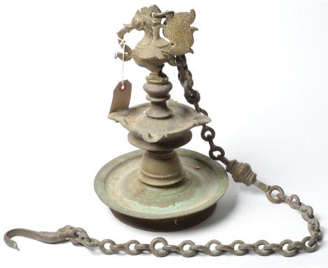 A heavy, Indian, 19th century, brass wick lamp, with peacock finial. The heavy brass chain with bird hook. 