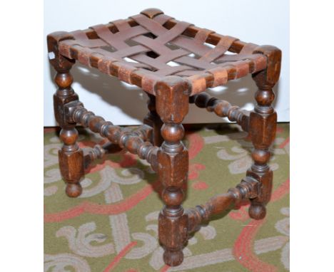 A stool in 17th century style with leather woven seat.