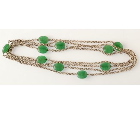 A long silver chain necklace spaced with green jade, oval beads. 