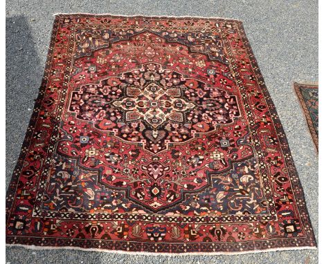 A hand knotted rug with central medallion and meandering palmette border, 300 x 215cm.
