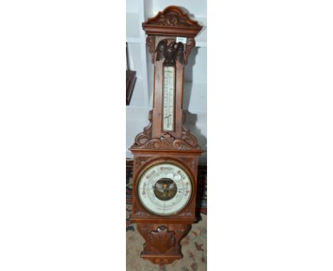 A late Victorian ornate carved aneroid barometer/thermometer.
