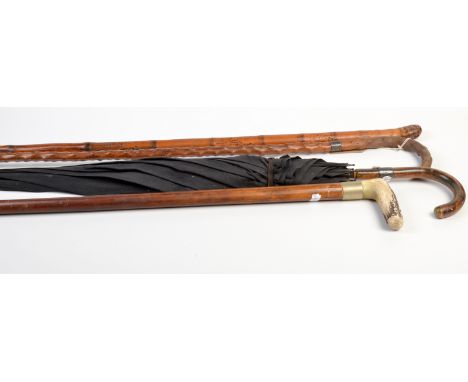 A stout malacca walking stick with antler handle together with a silver mounted walking stick and a silver mounted umbrella. 
