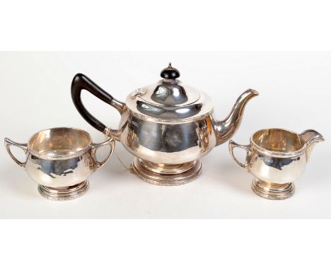 A Walker & Hall three piece silver tea service of rounded form on pedestal feet, Sheffield, 1922, 26ozs.