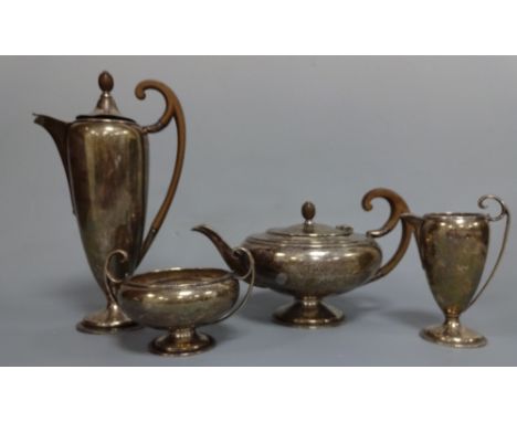 A SILVER FOUR PIECE ART DECO TEA SERVICE, comprising tapering hot water with ebonised high loop handle and finial to side hin