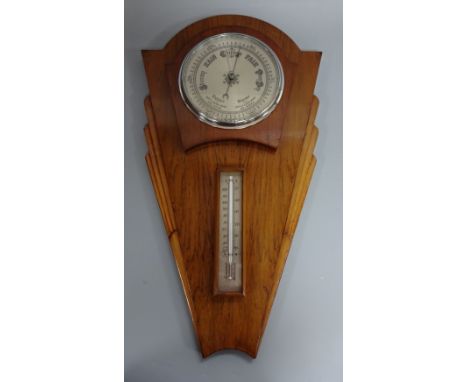 AN ART DECO STYLE OAK MOUNTED WALL HANGING BAROMETER, having circular silvered dial over thermometer, approximately 58cm x 29