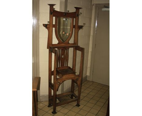 AN OAK ARTS & CRAFTS STYLE HALL STAND, having central bevelled shield mirror having three hooks over flanked by hooks, pierce