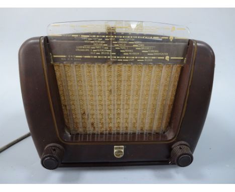 A PHILIPS BAKELITE RADIO, of shaped rectangular form having plastic waveband over central speaker, flanked by dials, label ve