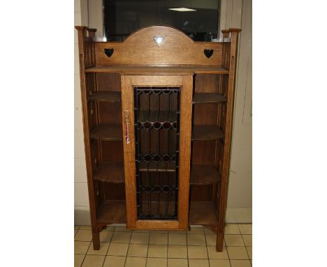 A LIGHT OAK BOWED ARTS & CRAFTS STYLE DISPLAY CABINET, having central glazed door to three shelf interior flanked by four she