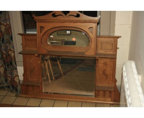 A GOLDEN OAK ARTS & CRAFTS STYLE OVERMANTLE MIRROR, having central rectangular bevelled glass flanked by shelves with inlaid 