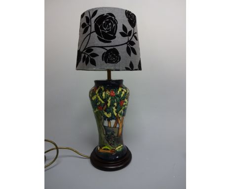 A MOORCROFT BALUSTER TABLE LAMP, tube line decorated in Holly Hatch design, on stepped wooden plinth, approximately 28cm high