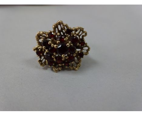 A 9CT GOLD GARNET RING, with cluster of garnets within an abstract surround, hallmarks rubbed, ring size K