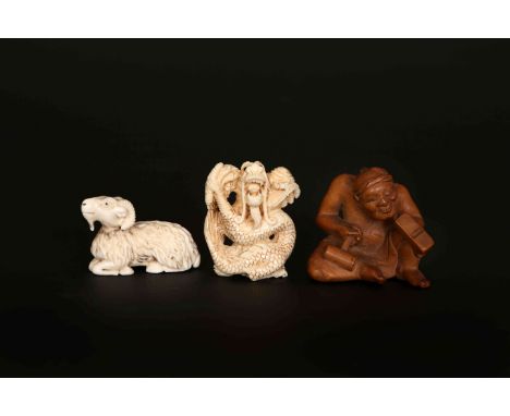 A JAPANESE WOODEN NETSUKE, carved as a carpenter eyeing his plane, 4cm high; and TWO JAPANESE IVORY NETSUKES, 19th/early 20th