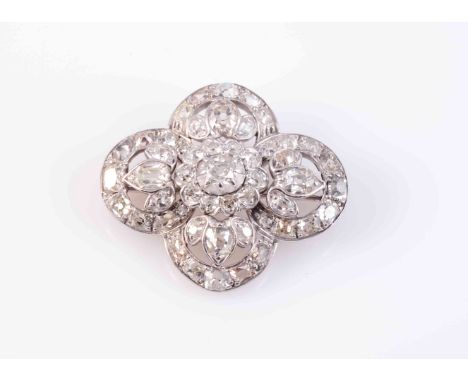 A DIAMOND SET BROOCH, CIRCA 1900, the oval mixed cut diamond claw and collet set in heavy mount within an inner scalloped edg