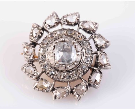 A DIAMOND BROOCH, CIRCA 1830-1840, the mixed cut diamond claw set in a heavy circular closed back mount within an inner surro
