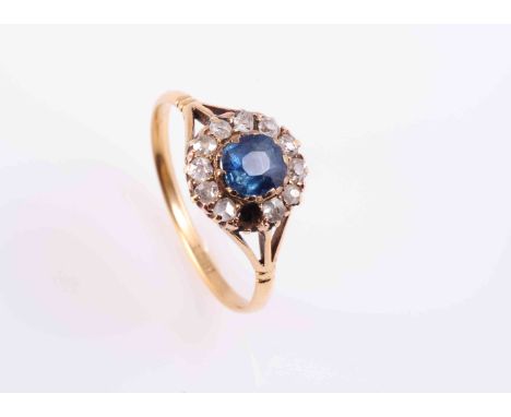 A SAPPHIRE AND DIAMOND RING, CIRCA 1890-1900, the round mixed cut sapphire claw and collet set within a surround of twelve ro
