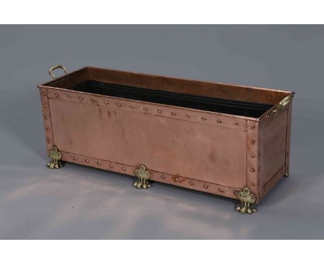 A POLISHED COPPER PLANTER, rectangular, raised on brass feet. 102cm