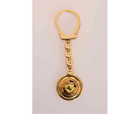 AN ITALIAN YELLOW METAL AND ENAMEL PORSCHE KEY FOB, Firenze, stamped 750 and indistinctly signed. 31 grams
