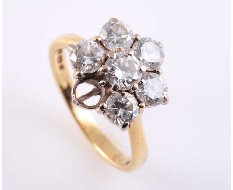 A DIAMOND CLUSTER RING, the brilliant cut diamond six claw set raised within a surround of six brilliant cut four claw set di