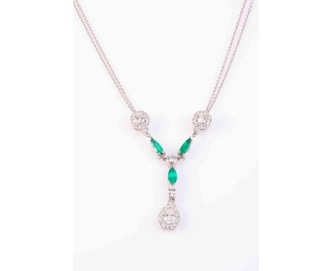 AN EMERALD AND DIAMOND PENDANT, the pear cut diamond ten claw set within a surround of ten brilliant cut diamonds, on an arti