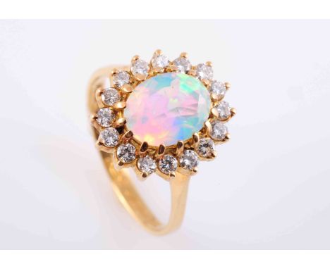 AN OPAL AND DIAMOND RING, the oval cut faceted opal sixteen claw set within a surround of sixteen brilliant cut claw set diam