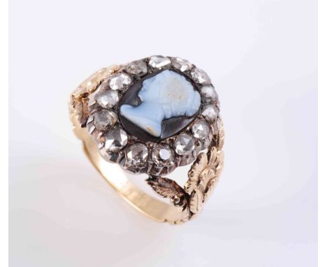 A DIAMOND SET CAMEO RING, CIRCA 1840-1850, the oval carved cameo of a woman's profile, set within a surround of fourteen rose