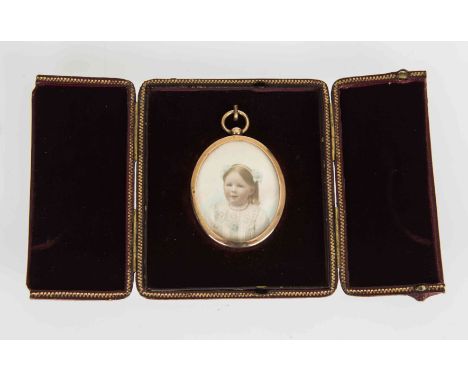 AN EARLY 20TH CENTURY PORTRAIT MINIATURE OF A YOUNG GIRL, oval, on ivory, yellow metal frame, in a leather travel case. 44mm 