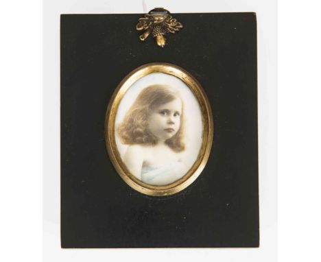 AN EARLY 20TH CENTURY PORTRAIT MINIATURE OF A GIRL, oval, on ivory, in an ebonised frame. Oval 70mm by 56mm