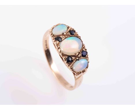 AN OPAL RING, CIRCA 1890, the three graduating oval cabochon cut opals alternately spaced with four round mixed cut sapphire 