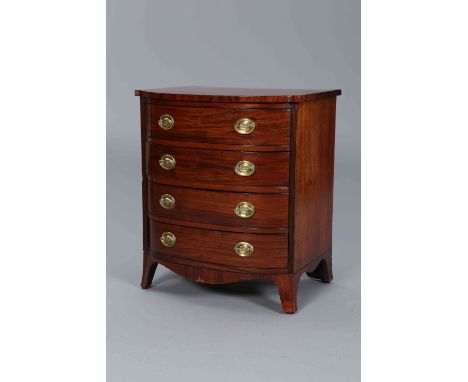 A SMALL REGENCY MAHOGANY CHEST OF DRAWERS, bow fronted, with four drawers fitted with brass oval backplate handles, flanked b